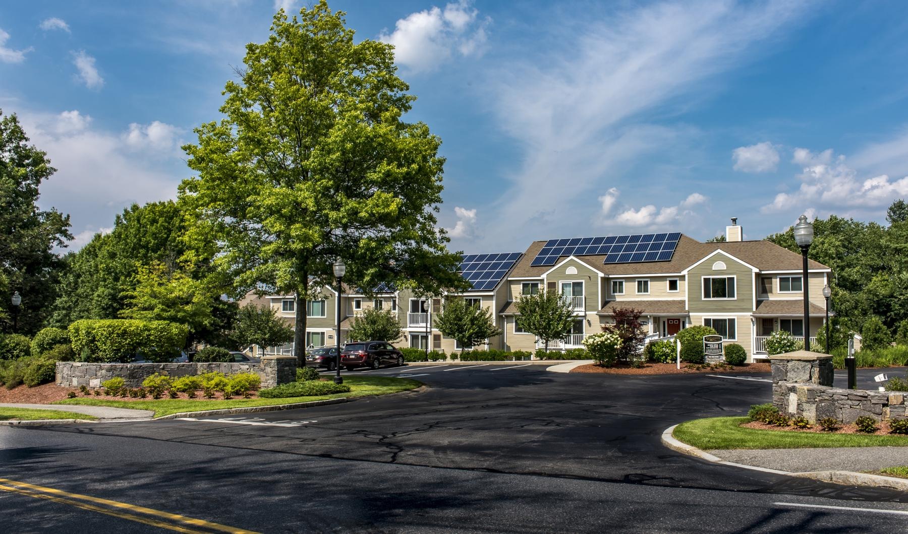 a large house with trees and a road in front of it