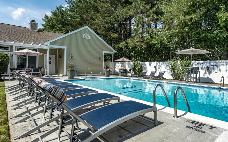 a swimming pool with chairs around it