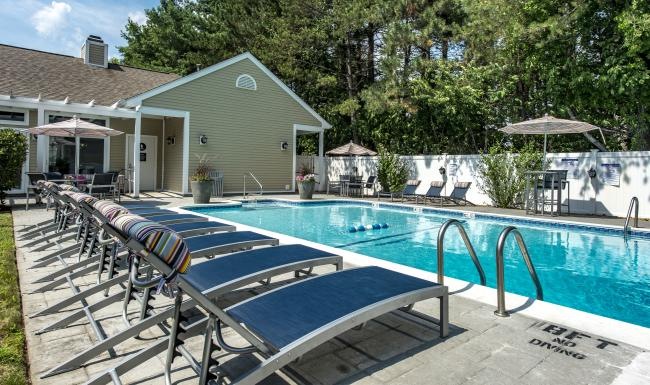 a swimming pool with chairs around it